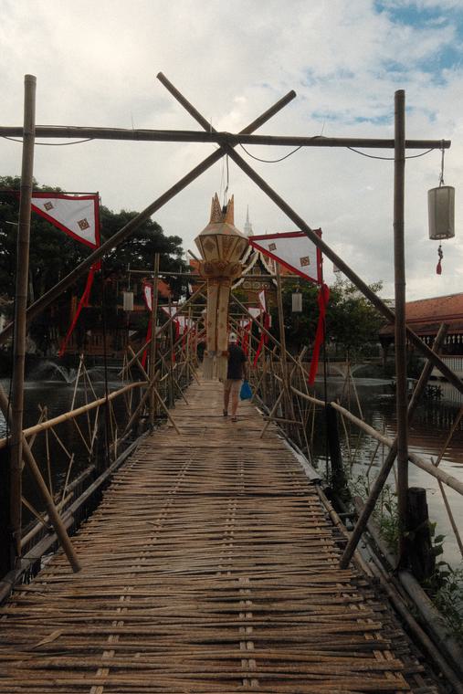 A bamboo footbridge, strung with flags