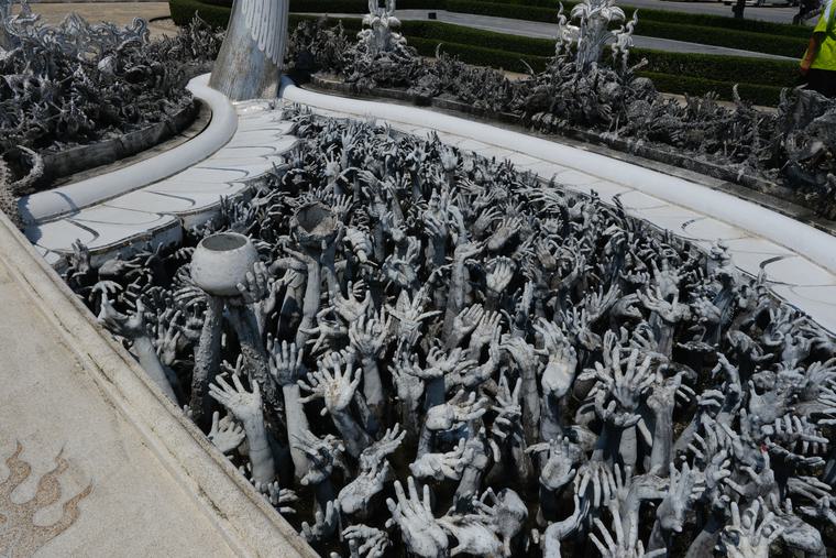 Hands reaching up out of the ground, under the bridge
